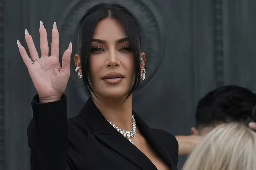 Kim Kardashian acena em um vestido preto.' typeof='foaf:Image' title=