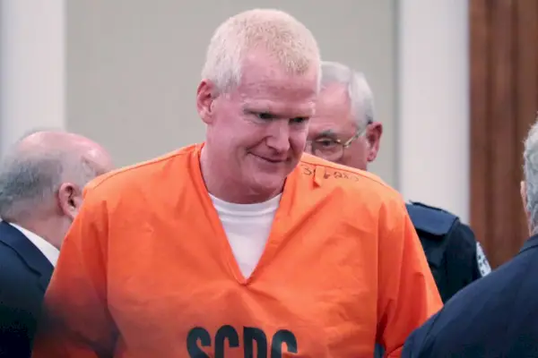 Alex Murdaugh ankommer retten smilende iført en oransje jumpsuit