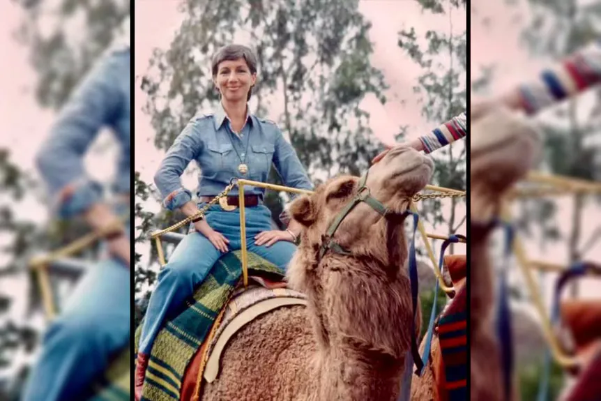 Una dona posa sobre un camell.' typeof='foaf:Image' title=