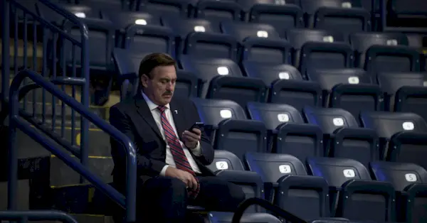 MyPillow CEOのマイク・リンデル氏が携帯電話をチェック