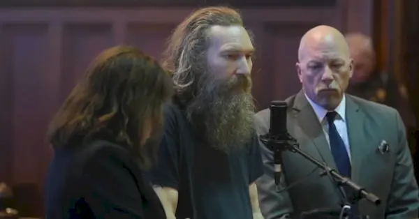 Марк Латунски (в центре) на слушании дела о признании вины 22 сентября 2022 года.